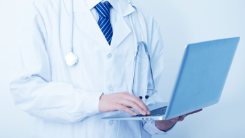 Male physician holding laptop
