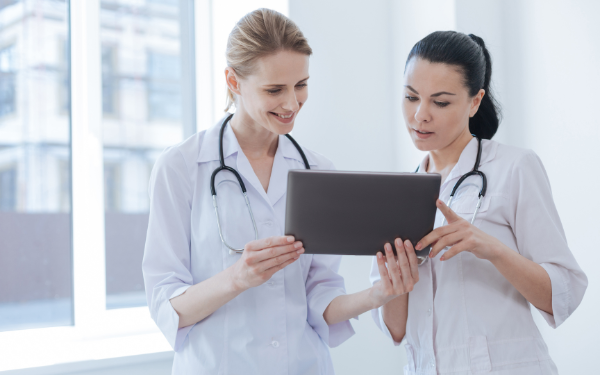 Two female physicians looking at a tablet