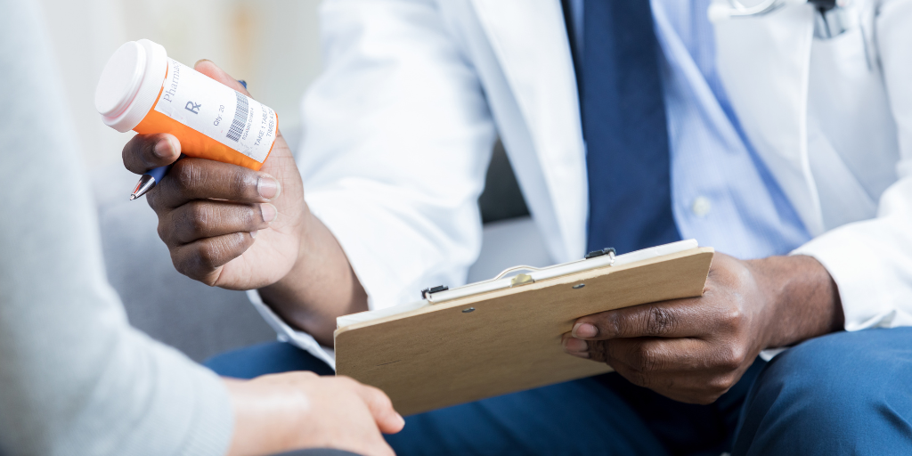 Doctor holding a bottle of pills to prescribe to a patient